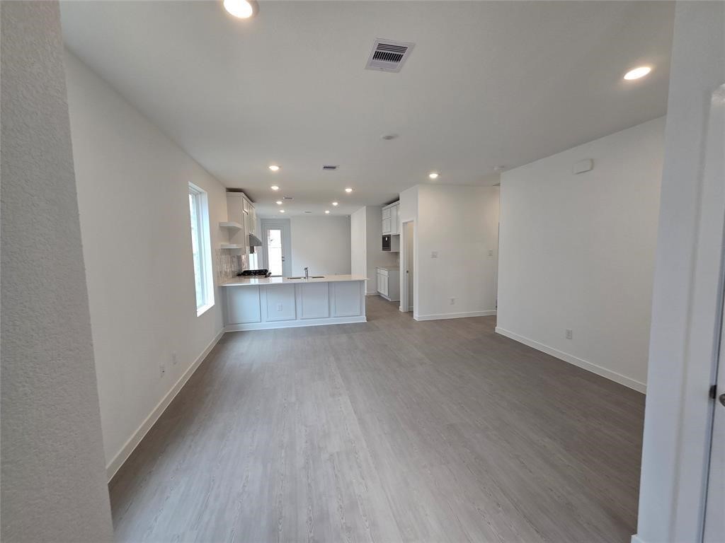 5718 Goosander Land Drive Baytown, TX 77521 - Photo 6 of 17 a view of a big room with wooden floor and windows