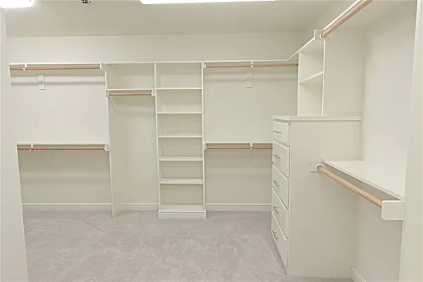 a view of walk in closet with empty racks