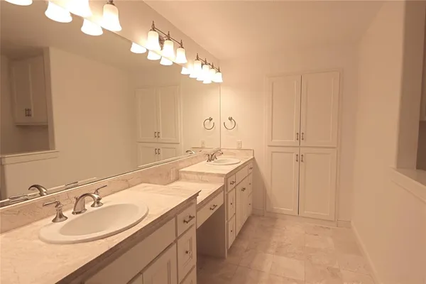a spacious bathroom with a double vanity sink and a mirror