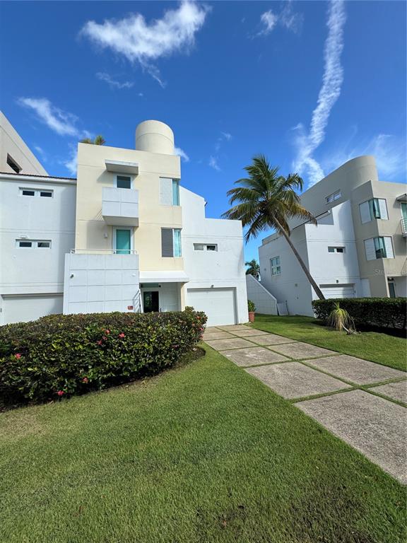 Villas De Golf East Villas De Golf East Dorado Del Mar Boulevard, Unit 91 Dorado, PR 00646 - Photo 2 of 15 a front view of a house with a garden and plants