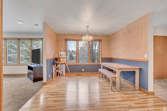 887 Village Way Alpine, UT 84004 - Photo 11 of 28 Dining area with wallpapered walls, light wood-style floors, wainscoting, a chandelier, and healthy amount of natural light