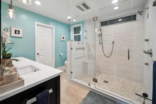 a bathroom with a shower sink and mirror