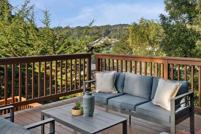 a balcony with wooden floor and outdoor seating