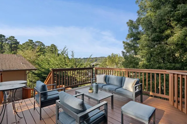 a roof deck with couches and wooden floor