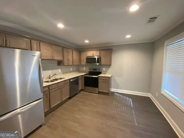 a kitchen with granite countertop stainless steel appliances and white cabinets