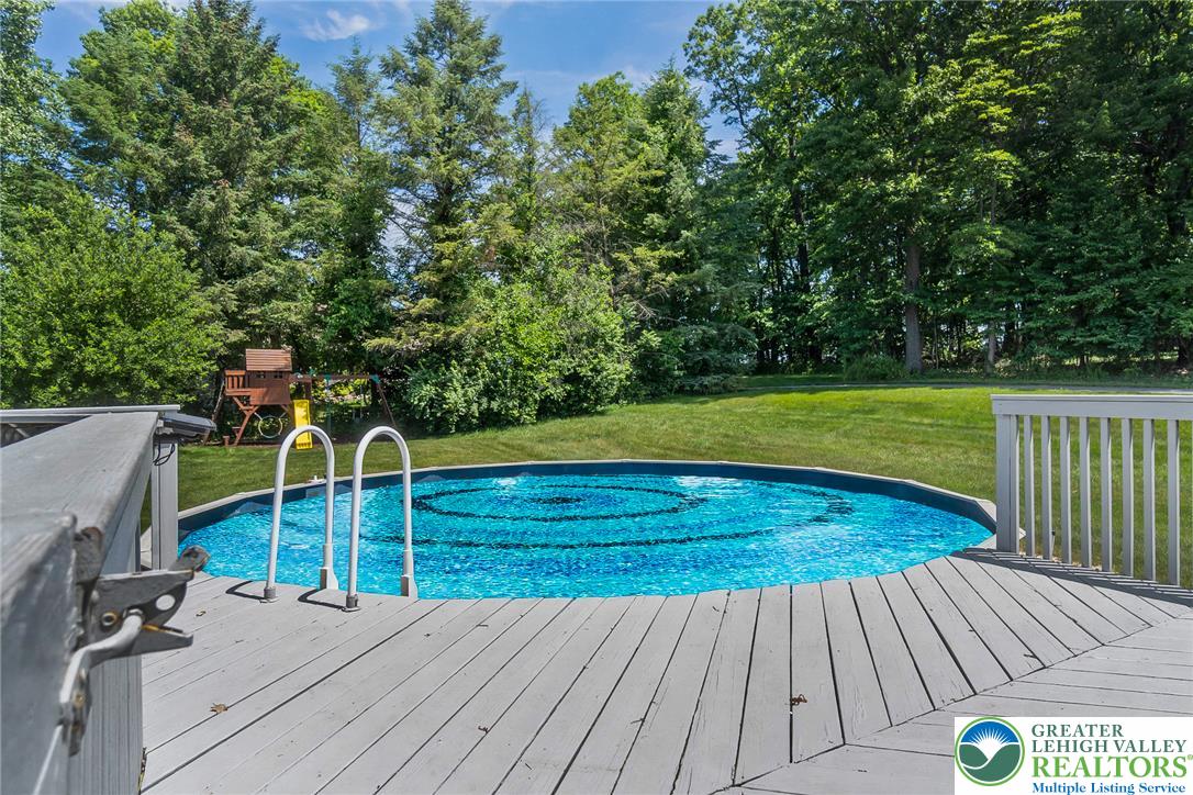 9461 Red Road Kempton, PA 19529 - Photo 38 of 55 A refreshing above-ground pool with a surrounding deck, set within a lush, private backyard.