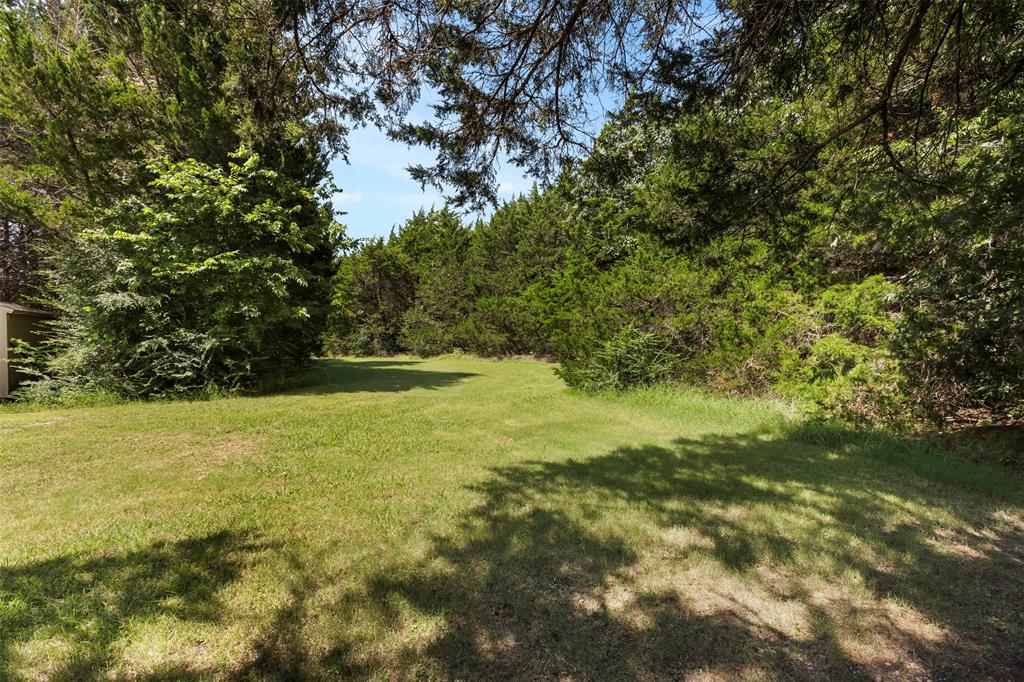 401 Rugged Drive Red Oak, TX 75154 - Photo 38 of 40 Expansive grassy area bordered by dense, mature trees