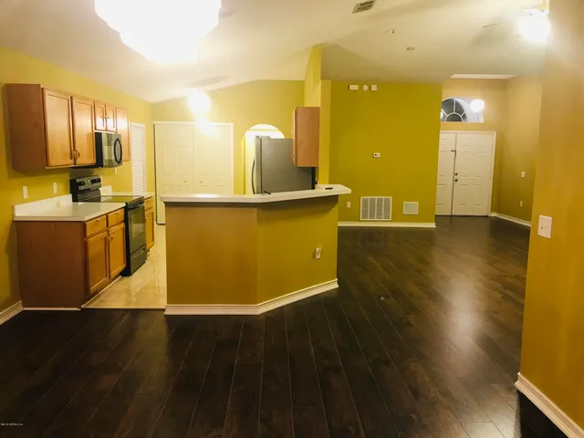 a view of a kitchen with kitchen island wooden floors