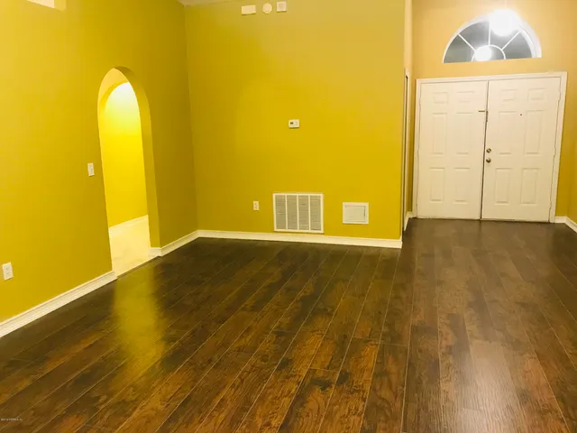 a view of a room with wooden floor and windows