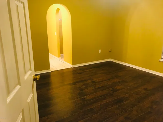 a view of a room with wooden floor and windows