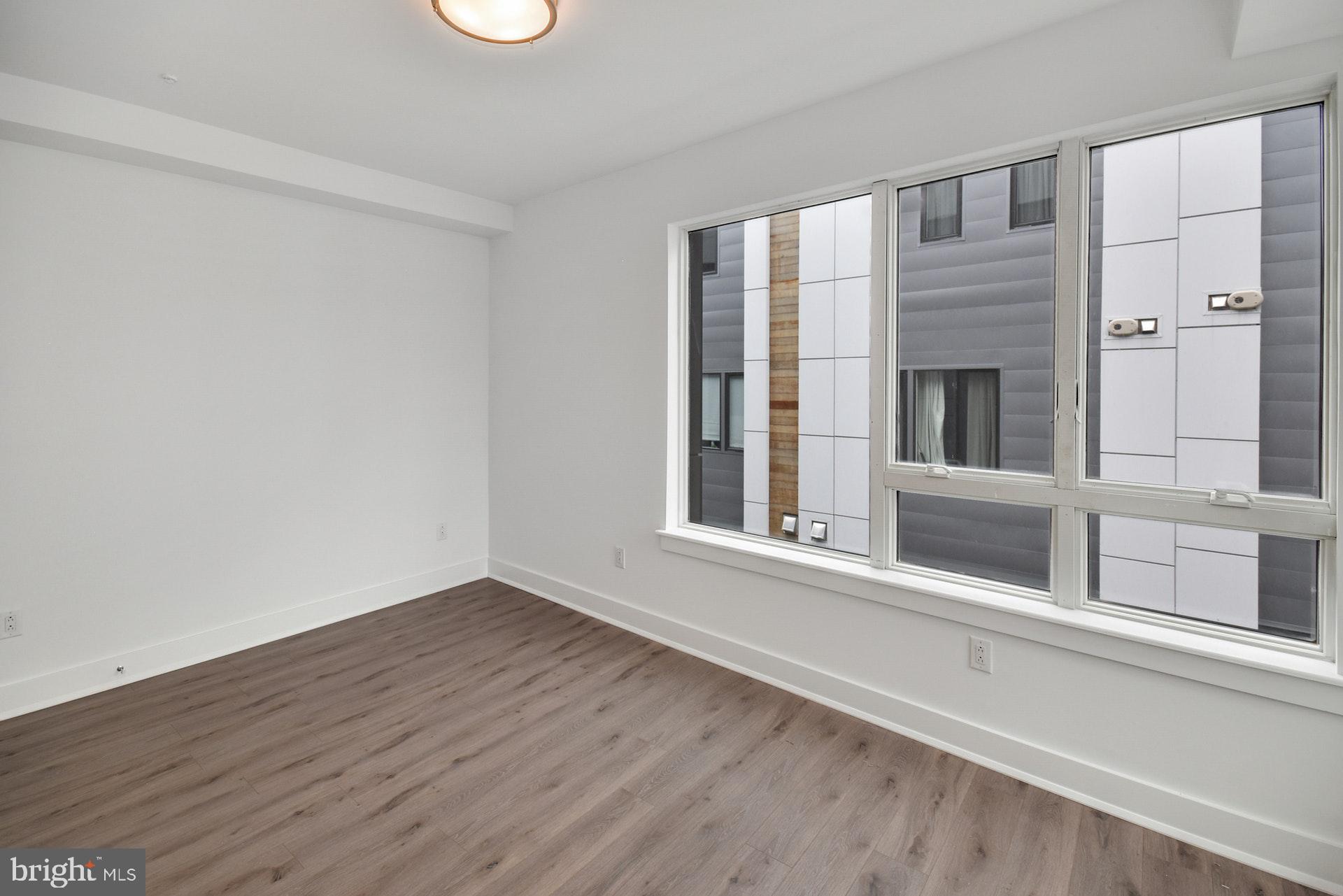 113 Olive Street Philadelphia, PA 19123 - Photo 16 of 33 a view of an empty room with a window and wooden floor