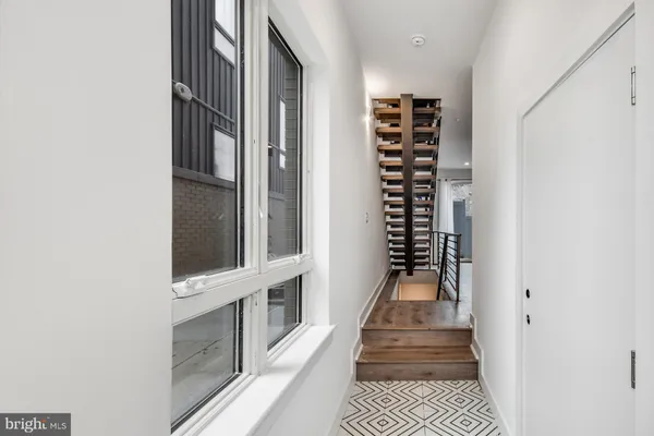 a view of a hallway with wooden floor and staircase