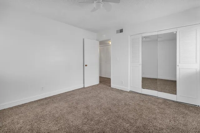 an empty room with a empty space and a ceiling fan