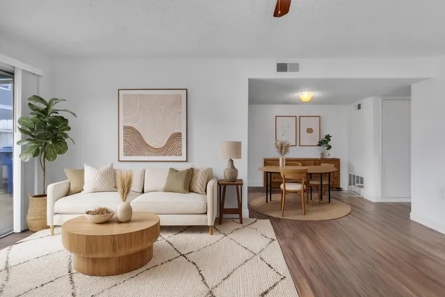 a living room with furniture and a dining table with kitchen view