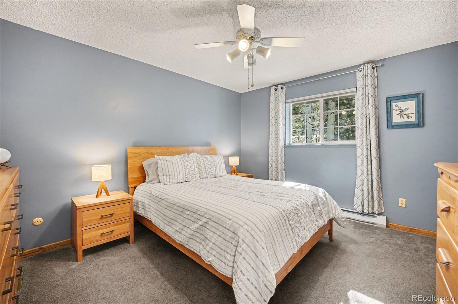 9780 South Warhawk Road Conifer, CO 80433 - Photo 15 of 44 a bedroom with a bed and a chandelier