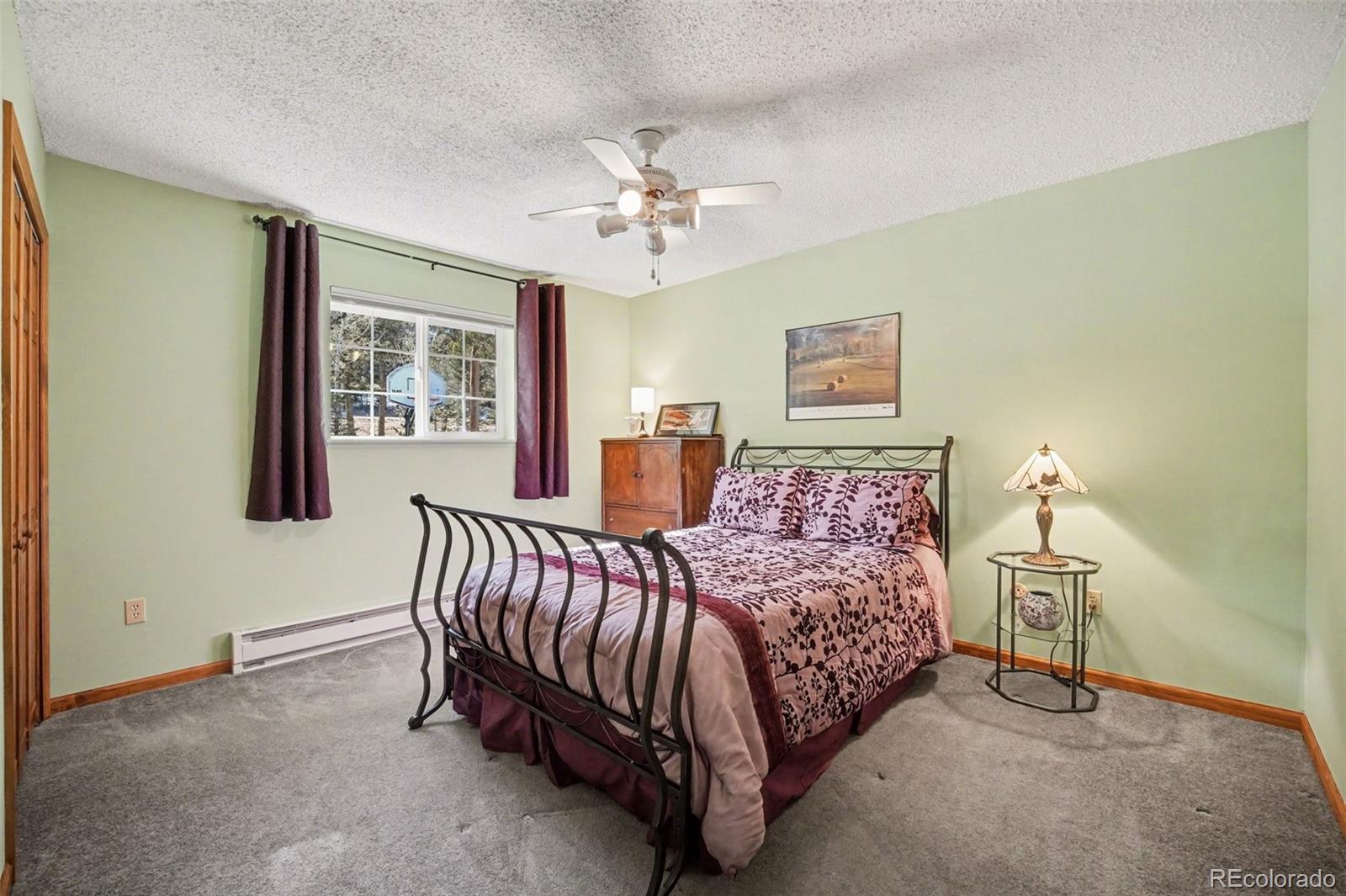 9780 South Warhawk Road Conifer, CO 80433 - Photo 16 of 44 a bed room with a bed and a chandelier