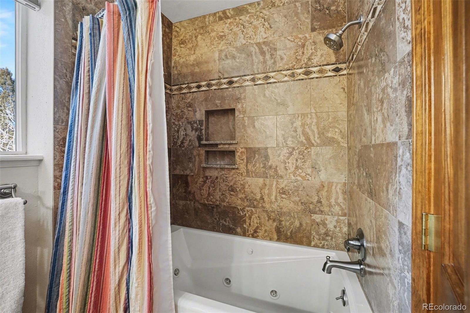 9780 South Warhawk Road Conifer, CO 80433 - Photo 20 of 44 a bathroom with a shower and a bath tub