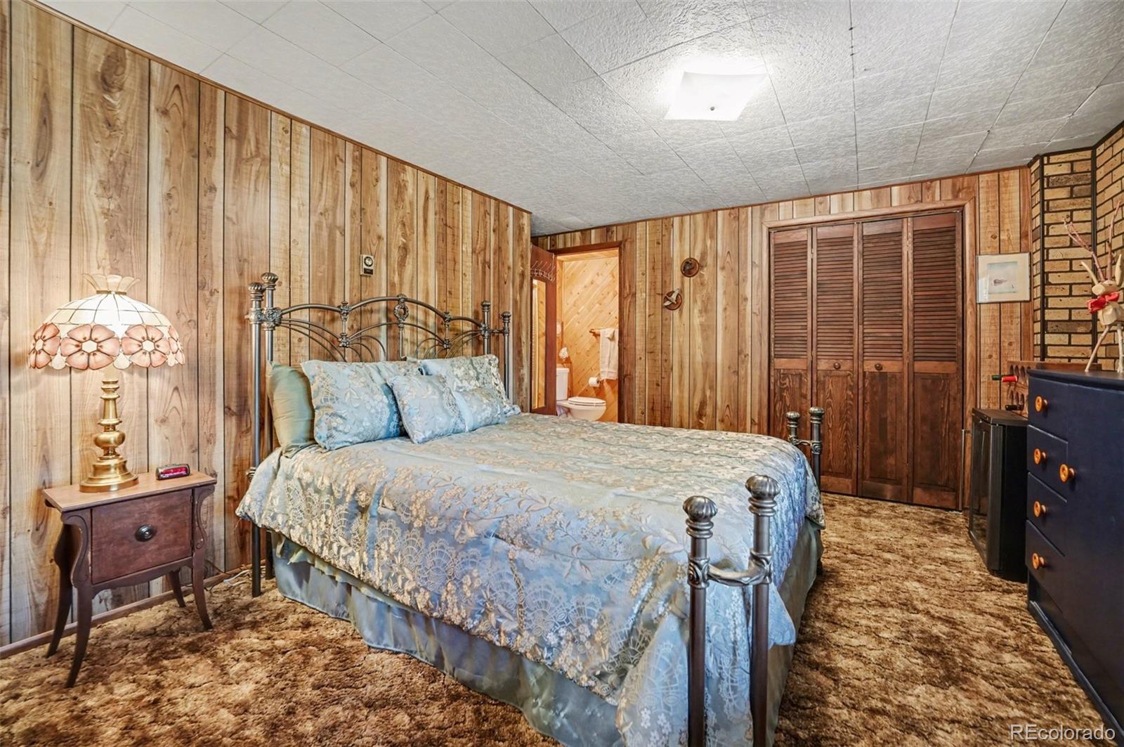 9780 South Warhawk Road Conifer, CO 80433 - Photo 29 of 44 a bed sitting in a spacious bedroom next to a window