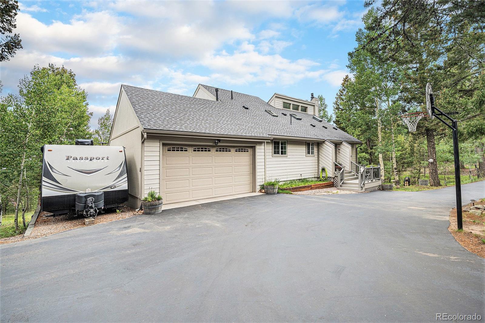 9780 South Warhawk Road Conifer, CO 80433 - Photo 41 of 44 a view of a house with backyard and parking area