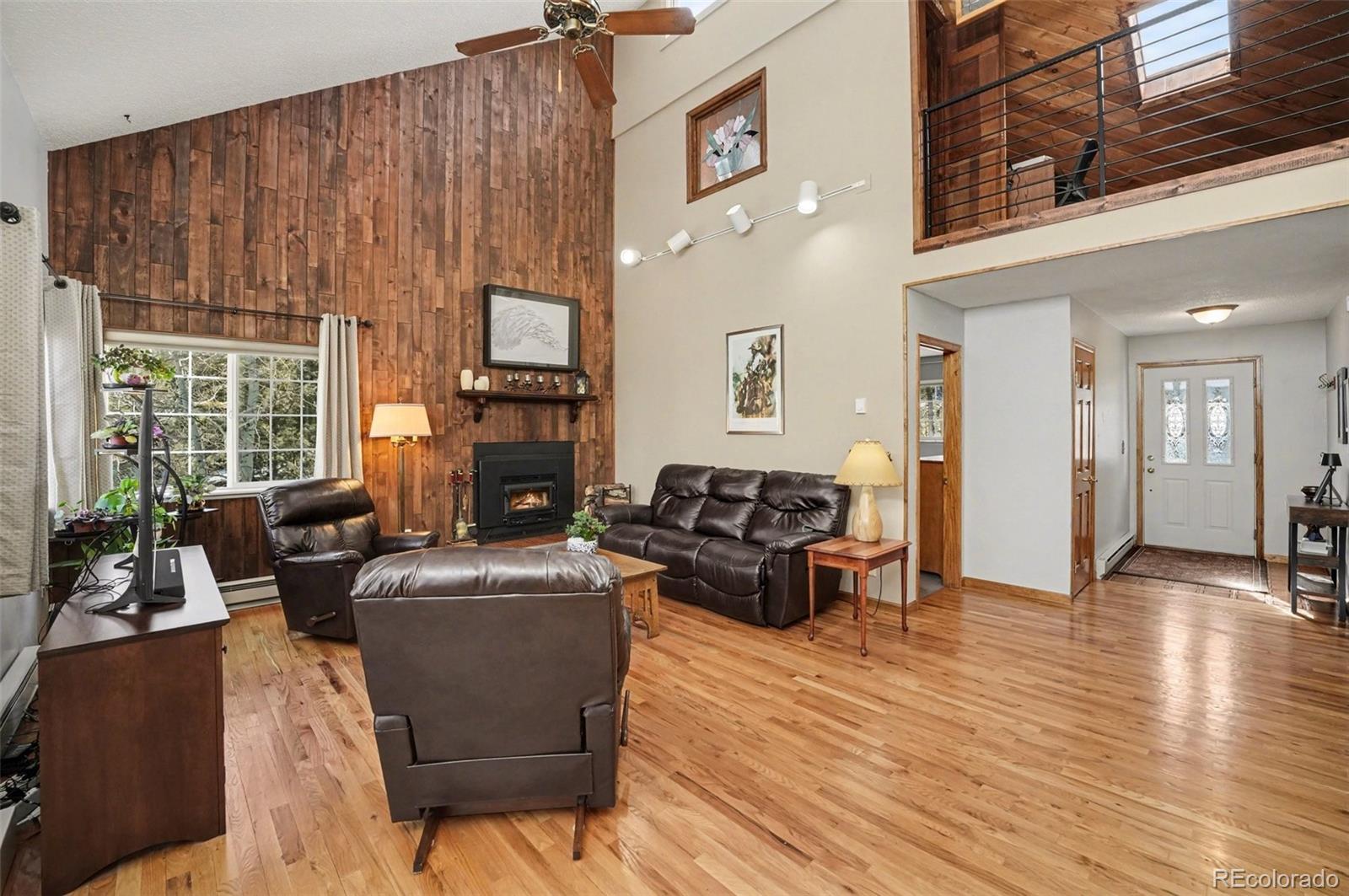 9780 South Warhawk Road Conifer, CO 80433 - Photo 8 of 44 a living room with furniture and a fireplace