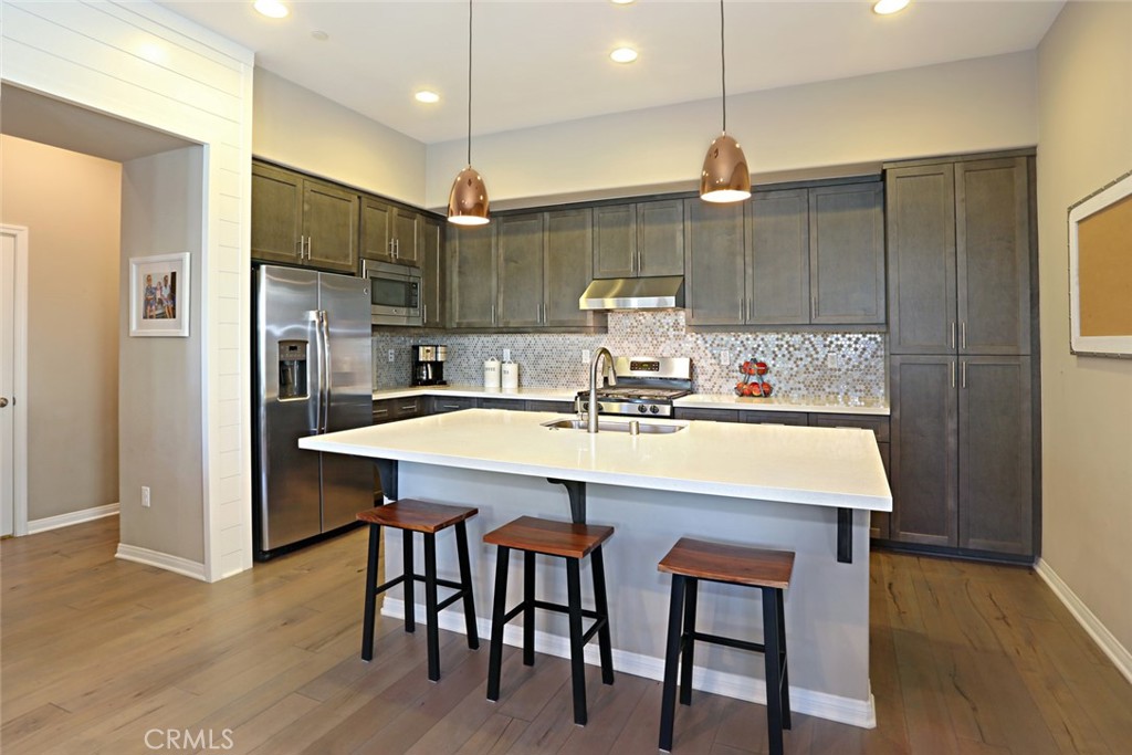 a kitchen with kitchen island stainless steel appliances a sink and a refrigerator
