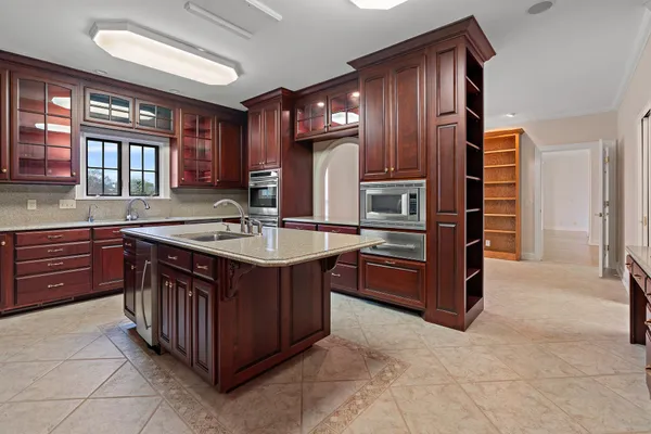 a kitchen with stainless steel appliances granite countertop a sink and a refrigerator