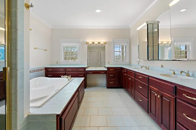 a large bathroom with a double vanity sink large mirror and a bathtub