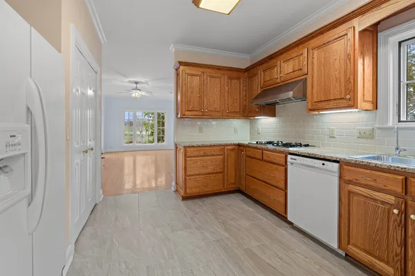 a kitchen with stainless steel appliances granite countertop a stove a sink and a refrigerator