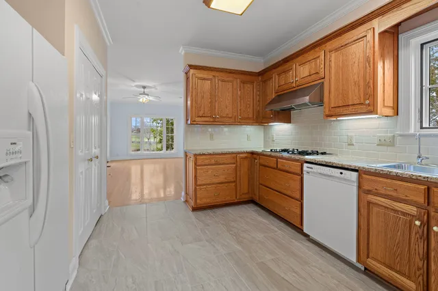 a kitchen with stainless steel appliances granite countertop a stove a sink and a refrigerator