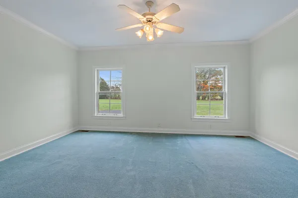 an empty room with a window and a fan