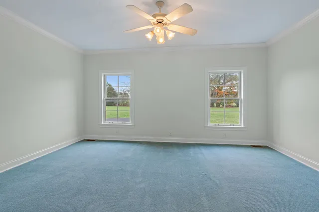 an empty room with a window and a fan