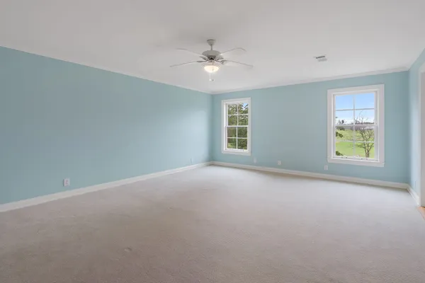 an empty room with a ceiling fan and window