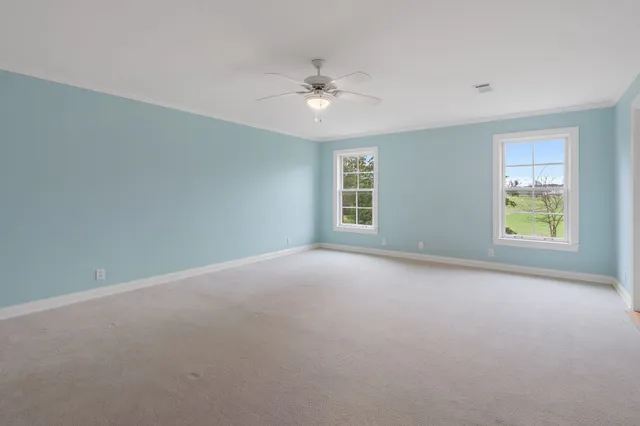 an empty room with a ceiling fan and window