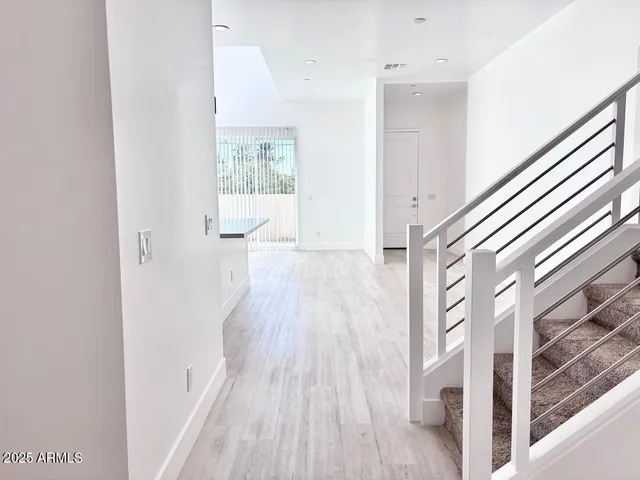 a view of a hallway with wooden floor and staircase