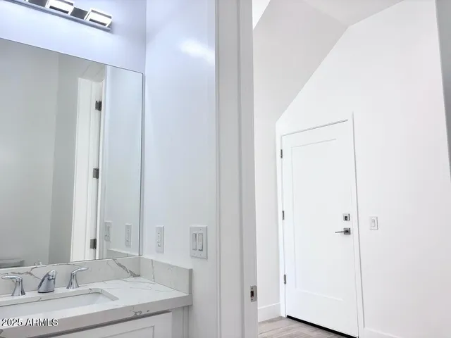 a bathroom with a granite countertop sink and a mirror