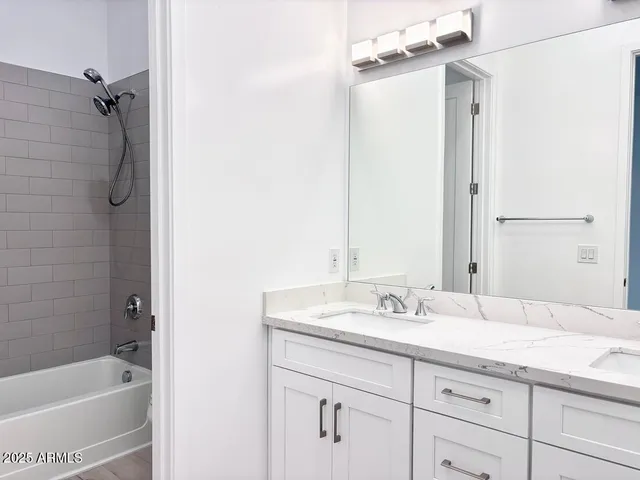 a bathroom with a granite countertop sink mirror and a bathtub