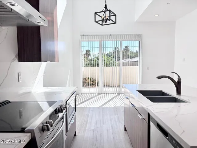 a kitchen with a stove a sink and a cabinets with wooden floor