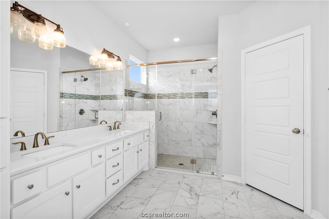 36244 Cochran Road Waller, TX 77484 - Photo 20 of 41 a bathroom with a double vanity sink mirror and shower