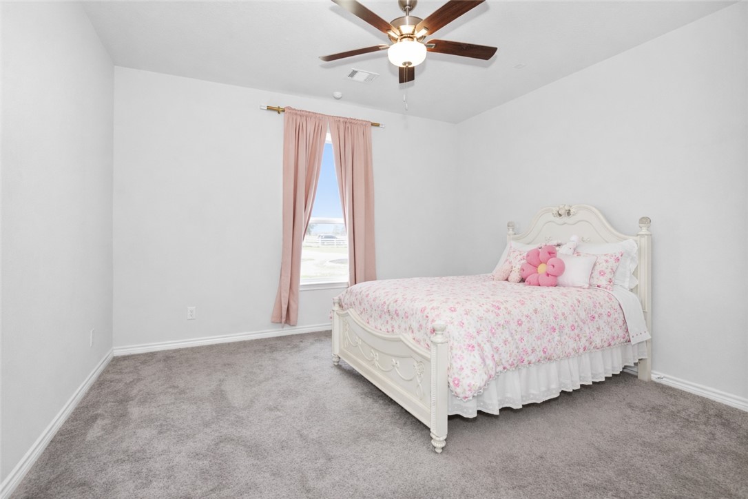 36244 Cochran Road Waller, TX 77484 - Photo 26 of 41 a bedroom with a bed and a chandelier