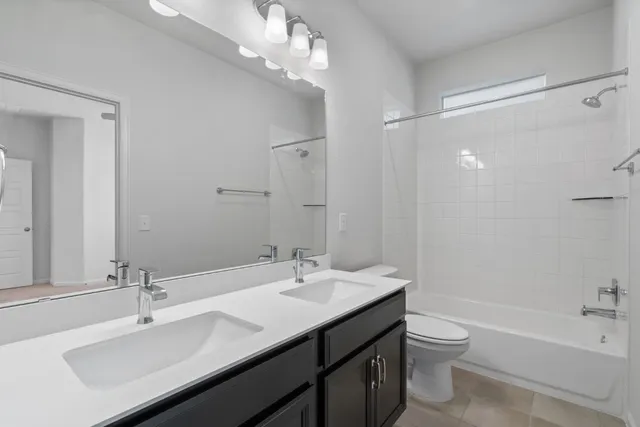 a bathroom with a sink a toilet and a large mirror