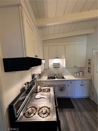 a kitchen with granite countertop a stove a sink and a microwave