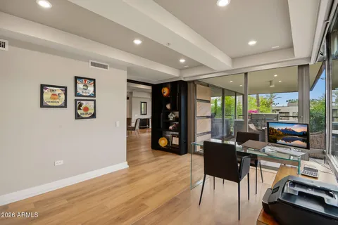 a kitchen with stainless steel appliances granite countertop a stove a refrigerator a microwave oven with white cabinets and wooden floor