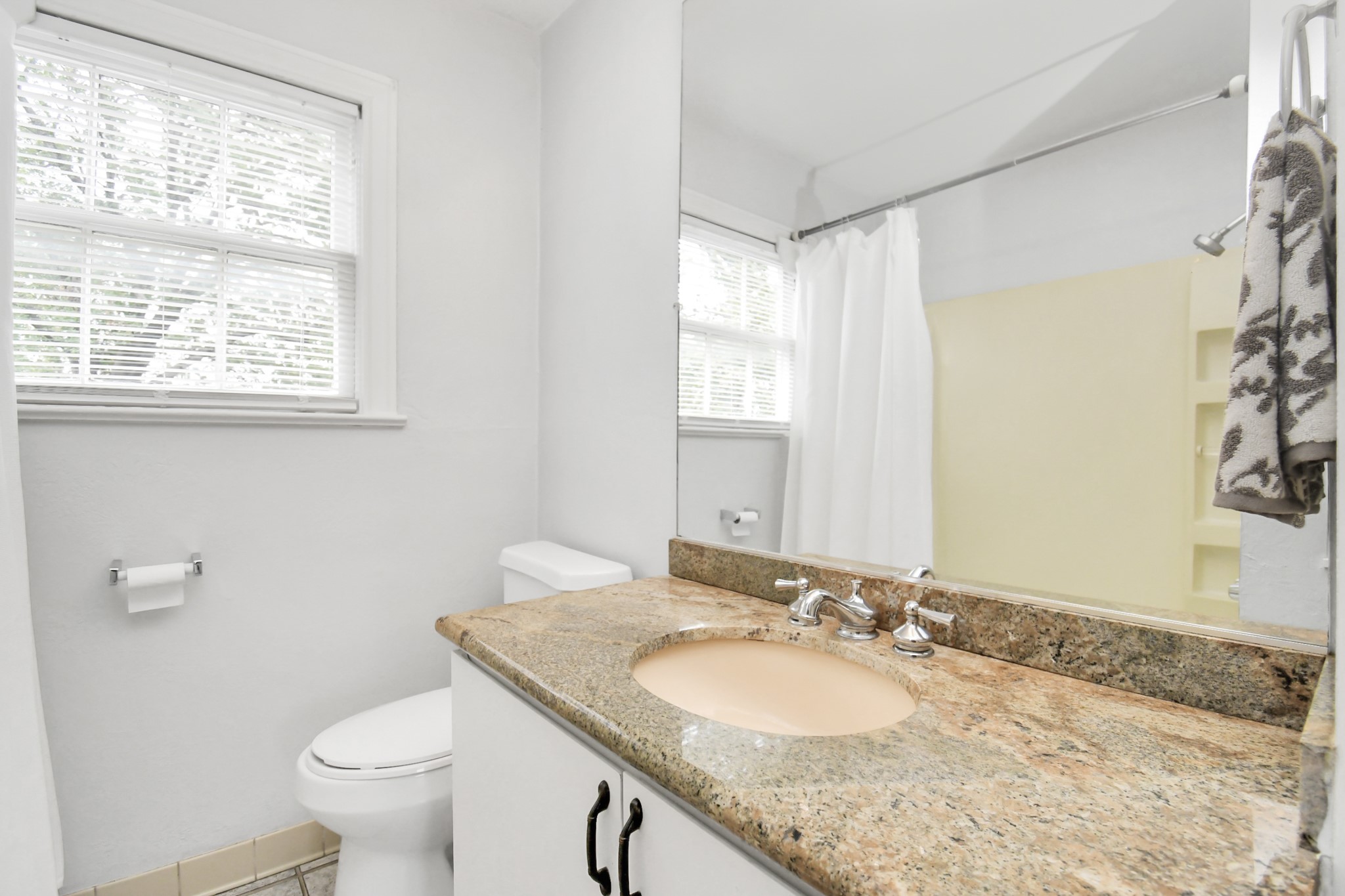 109 Amundsen Street Houston, TX 77009 - Photo 13 of 40 a bathroom with a granite countertop sink a toilet and a mirror