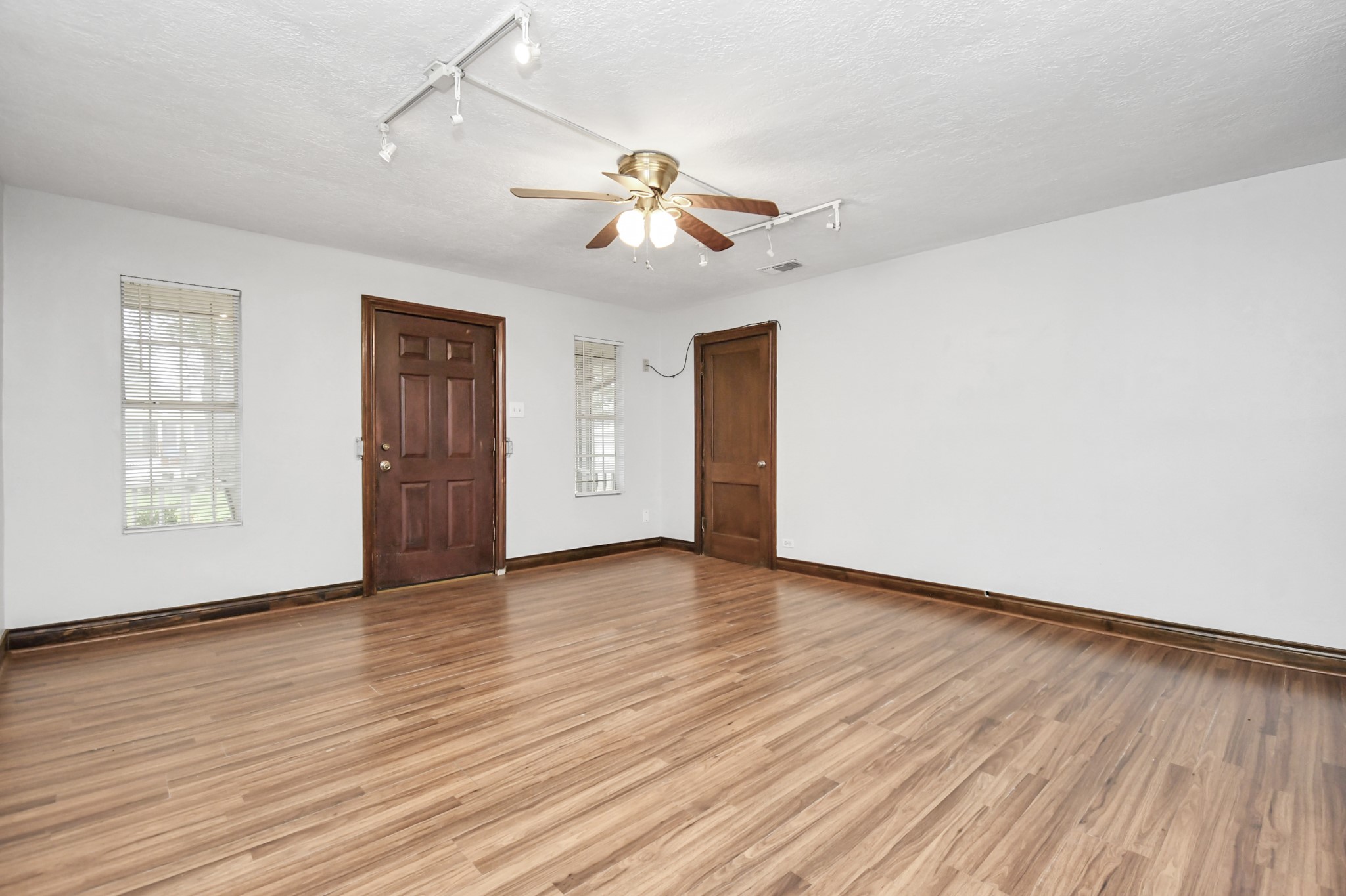 109 Amundsen Street Houston, TX 77009 - Photo 7 of 40 an empty room with wooden floor ceiling fan and windows