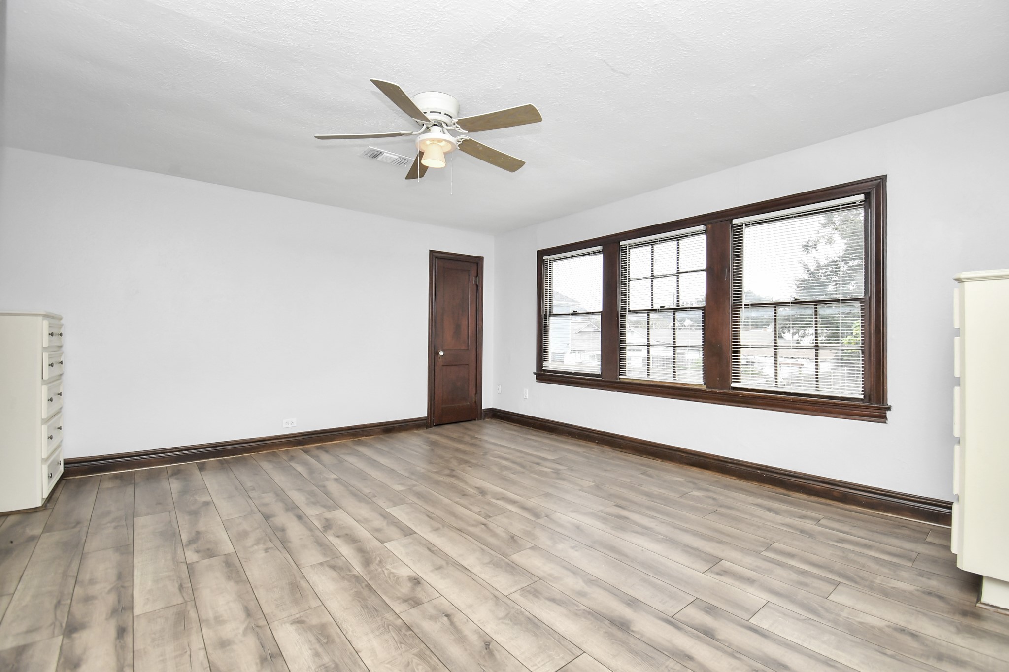109 Amundsen Street Houston, TX 77009 - Photo 9 of 40 a view of an empty room with wooden floor and a window
