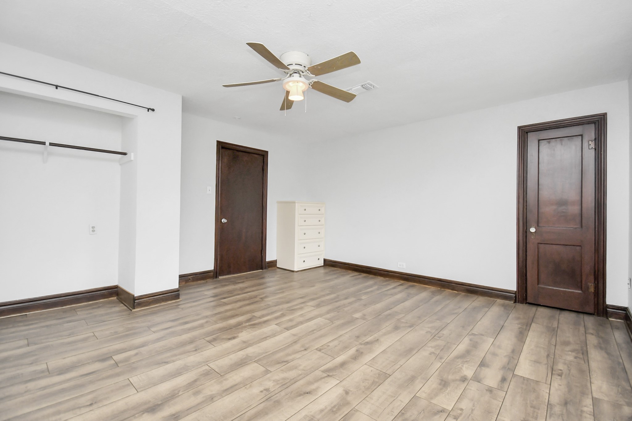 109 Amundsen Street Houston, TX 77009 - Photo 10 of 40 an empty room with wooden floor and a ceiling fan