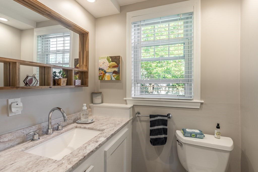 7 Charles Street Maynard, MA 01754 - Photo 13 of 33 a bathroom with a granite countertop toilet a sink and a window