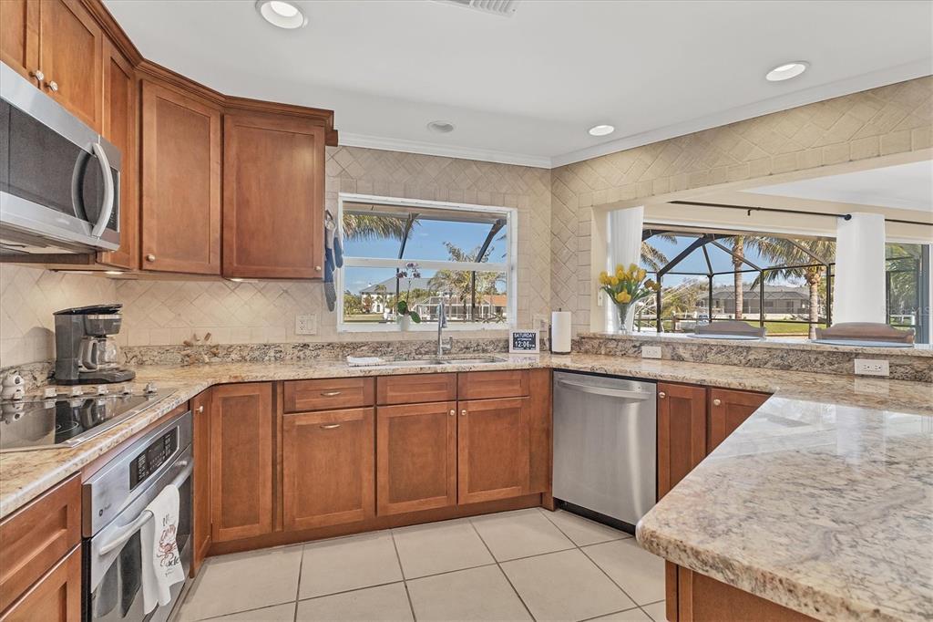 30 Buccaneer Bend Placida, FL 33946 - Photo 19 of 38 a kitchen with stainless steel appliances granite countertop a sink and dishwasher a stove top oven with wooden floor