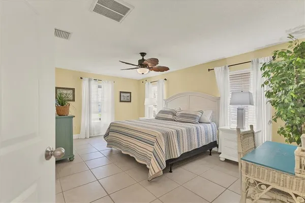 a spacious bedroom with a bed and a chair