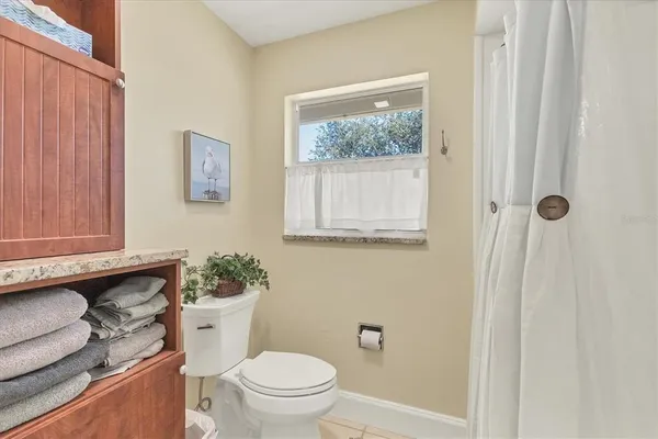 a bathroom with a toilet a sink and a window